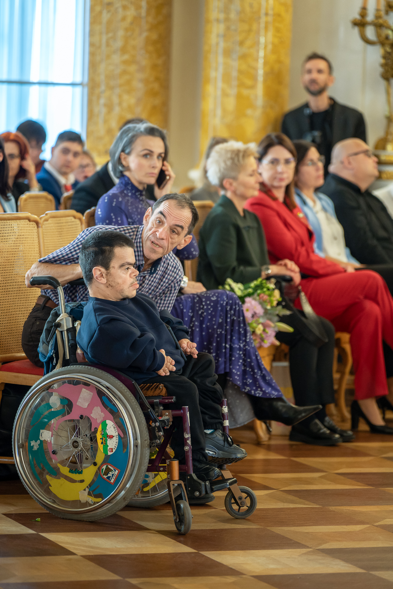 Zdjęcie publiczności gali, wśród której jest mężczyzna na wózku.