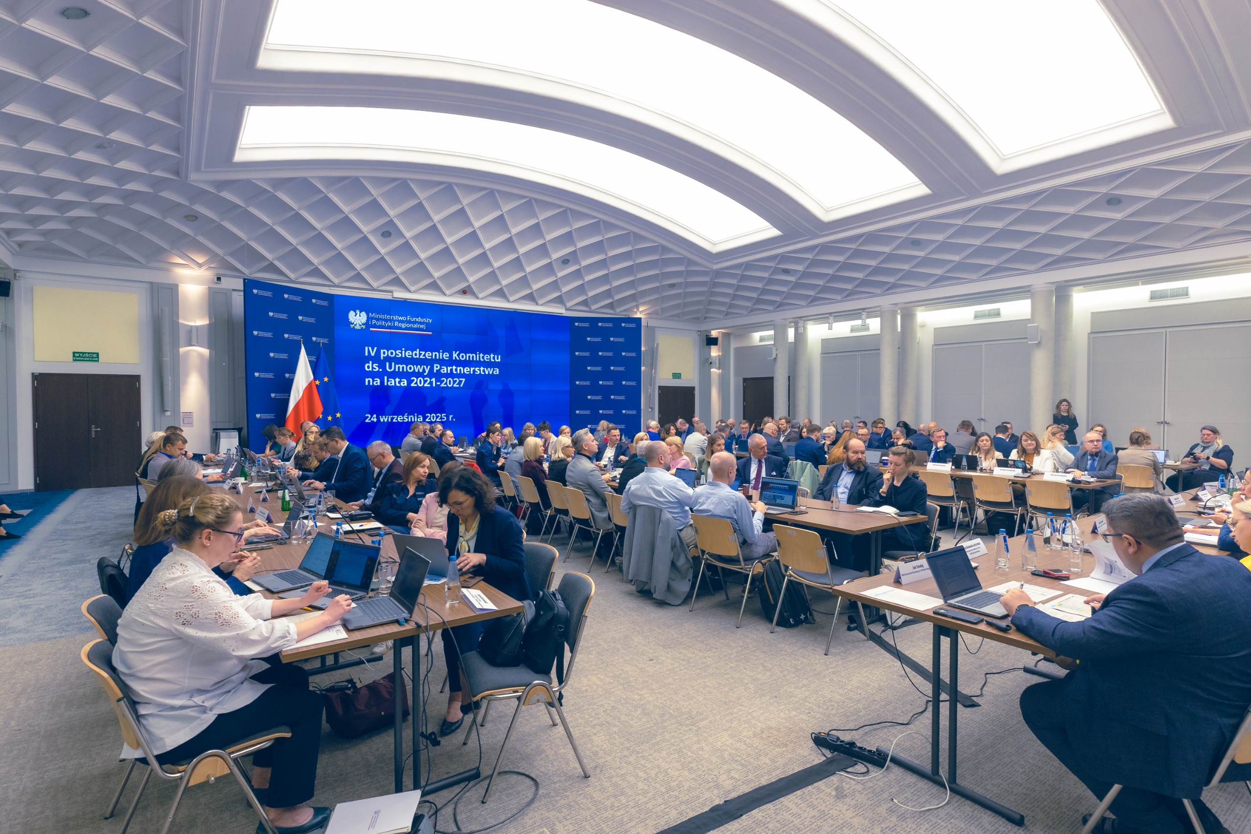 Widok dużej sali konferencyjnej i kilkudziesięciu osób przy stołach na obradach komitetu