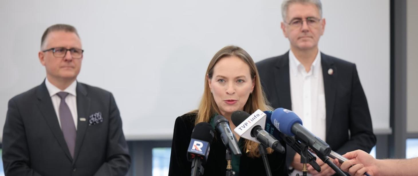 Minister wraz z przedstawicielami instytucji przemawiająca na spotkaniu do przedsiębiorców