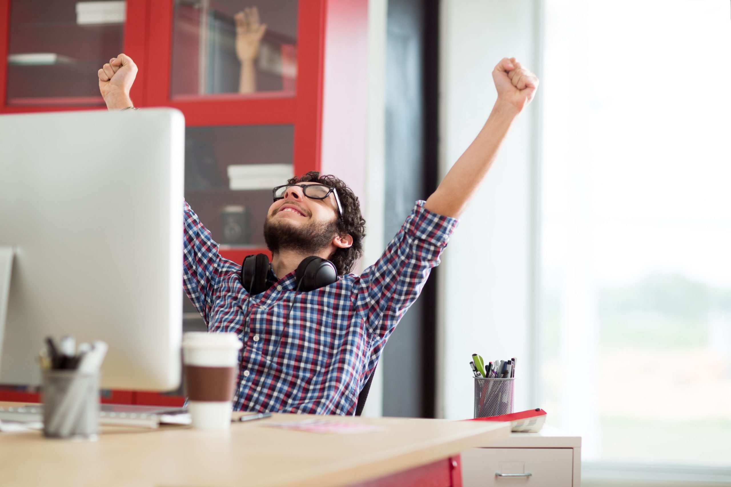 Młody mężczyzna unosi ręce w geście zwycięstwa