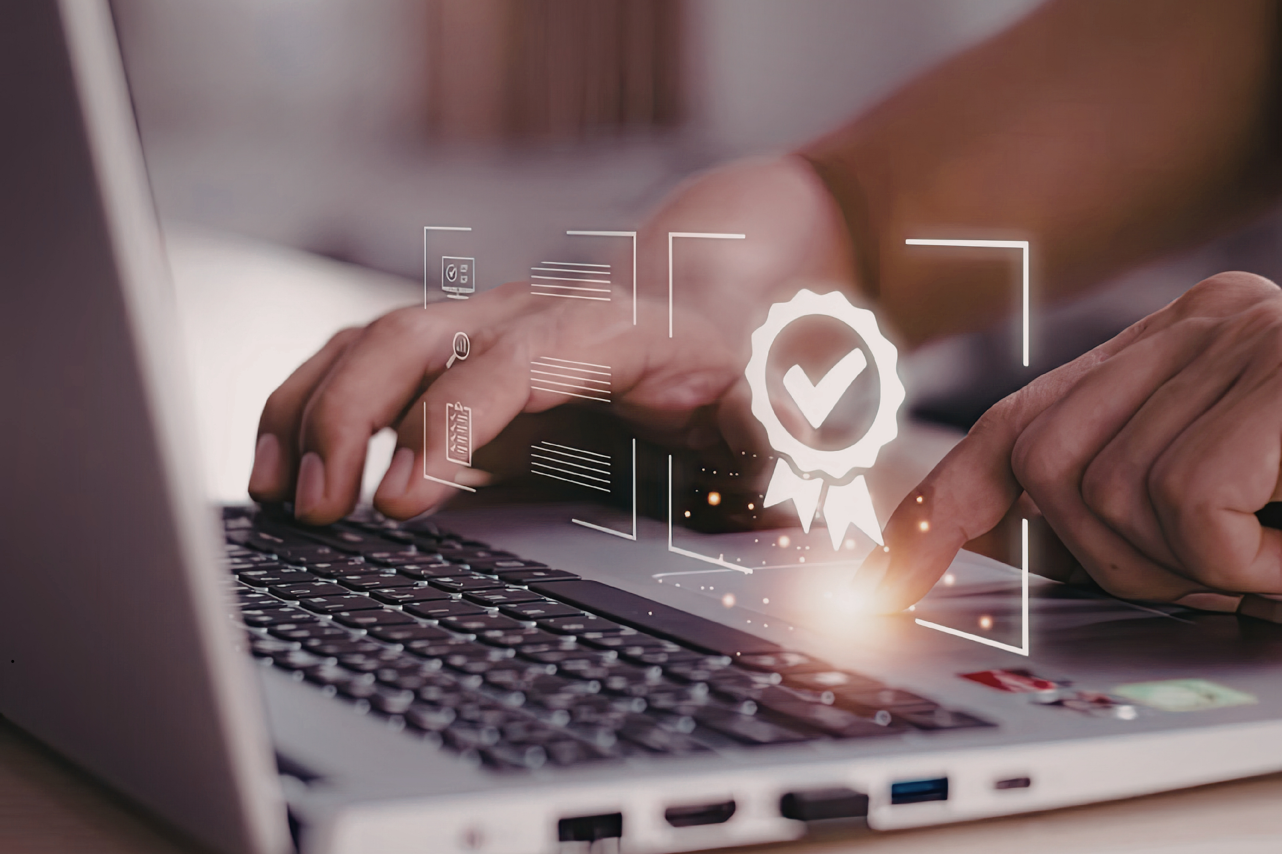Męskie dłonie na klawiaturze laptopa. Nad klawiaturą widoczna grafika symbolizująca poprawność danych.