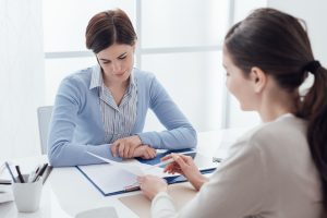 Młode kobiety konsultują dokumenty przy biurku
