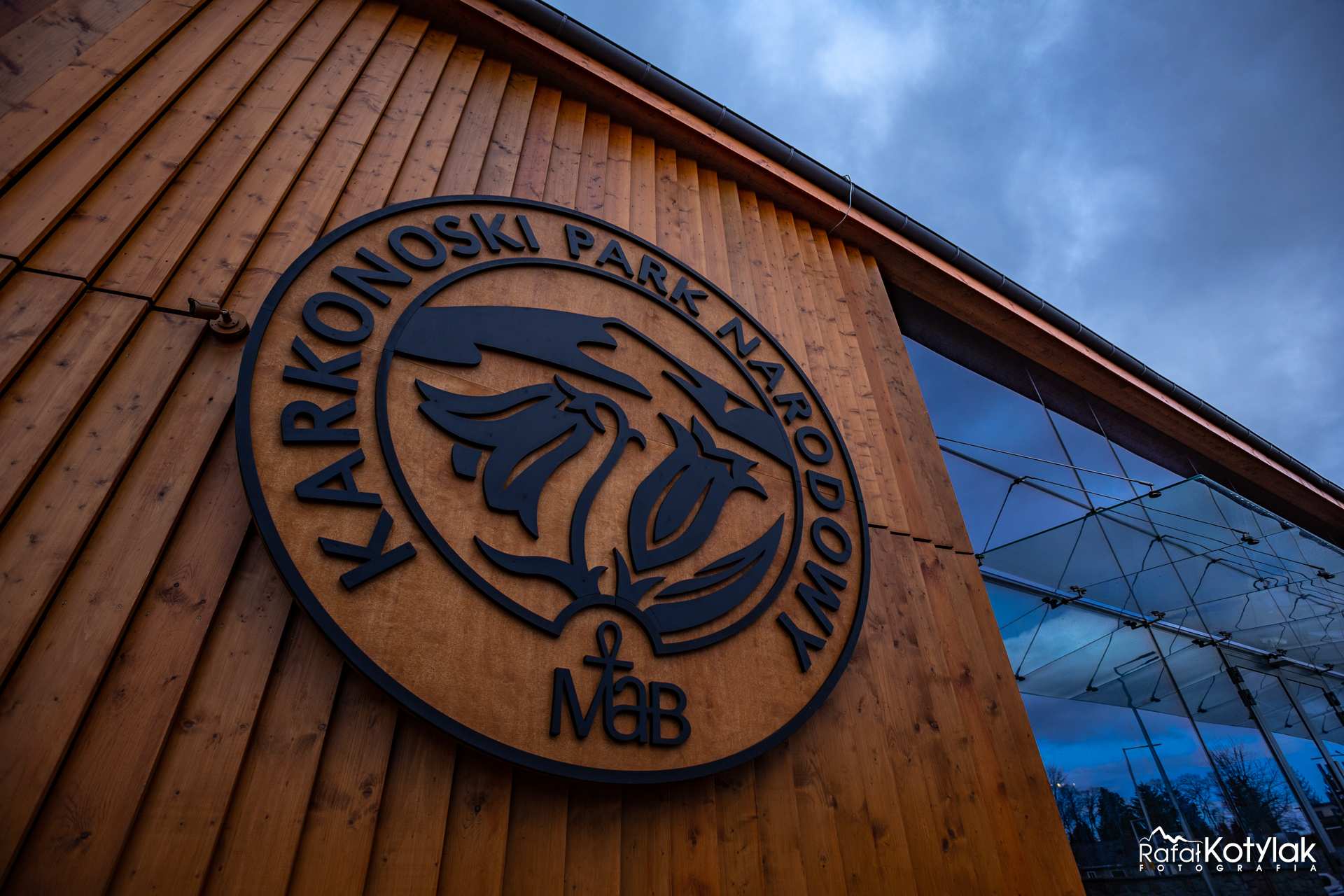 Na drewnianej ścianie budynku logo Karkonoskiego Parku Narodowego