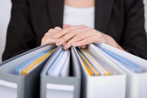 widok segregatorów i dłonie na nich
